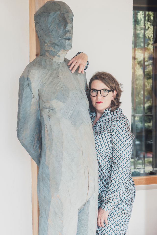 Petra Reindl, Interim CFO in München, neben einer Steinstatue eines Menschen, ihre Hand auf der Schulter der Figur